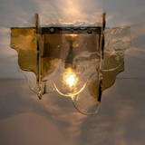 Decorative wall light fixture with glass shade on a neutral background