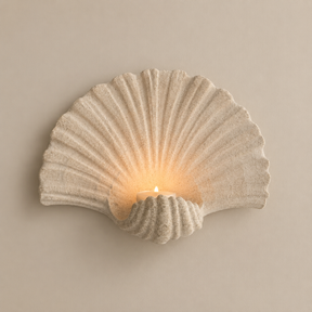 Shell-shaped wall-mounted candle holder on a premium neutral background