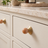Solvi Brass Ball Cabinet Knobs - Apricot - Lifestyle on cream cabinetry