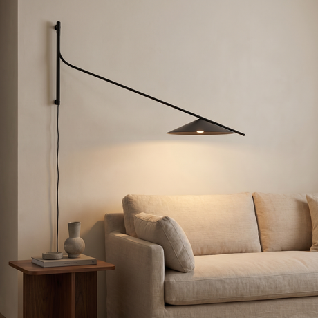 Soren Reach adjustable black LED wall lamp above a beige sofa