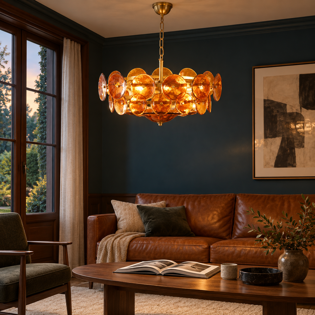Velari Disc Orange Glass Chandelier glowing warmly above a walnut coffee table in a lounge with blue walls and a cognac leather sofa.