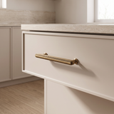Veyra solid brass medium cabinet pull installed on warm neutral kitchen cabinetry