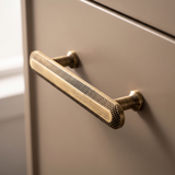 Close-up of Veyra solid brass medium cabinet pull showing knurled antique bronze detailing
