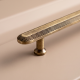 Close-up of Veyra solid brass round cabinet knob with fine knurled antique bronze finish